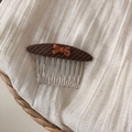 Détail d'un peigne à cheveux en tissu rayé marron avec un petit nœud orange élégant - Peigne à Cheveux Ovale Rose