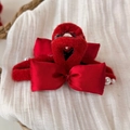 Detail of red plush hair claw with satin bow and pearl accents for festive hair styling - Red Hair Claw