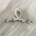 Detail of gray marble acetate hair claw clip with golden spring on textured fabric - Creamy White Ink Style (Style E)
