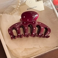 Vista dettagliata della grande clip per capelli bordeaux a pois nella scatola regalo - Molla per capelli alla zucca