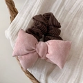 Détail d'une pince à cheveux rose avec tissu rayé marron sur fond de texture douce - Chouchou Noeud Rose