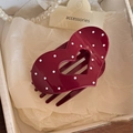 Dettaglio del fermaglio per capelli rosso scuro a cuore con pois bianchi su scatola - Molletta a Cuore