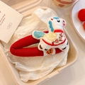 Close-up of a festive red embroidered pony hair clip for children with floral patterns - White Pony