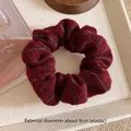 Close-up of a burgundy knitted scrunchie with navy stripes and 9cm outer diameter - Small Red