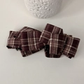 Detail of retro plaid fabric bow hair clip with dark brown checkered textile texture - Plum Check