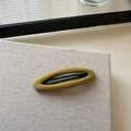 Detalle de la textura de tela amarillo mostaza en una pinza para el cabello hecha a mano coreana - Ovalado Hueco Amarillo