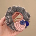 Detail of grey plush scrunchie with pink hand-knitted bag charm and blue flower detail - Small Pink Jacquard Bag