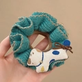 Gros plan détaillé du chouchou tricoté bleu avec une adorable petite poupée chien - Chiot Blanc