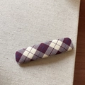 Detail view of a purple argyle fabric hair clip with classic check pattern on linen - Plaid / Rectangular Style / Purple and White