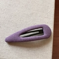 Dettaglio macro del tessuto intrecciato lavanda su una molletta clic clac in metallo - Stile a Goccia Svuotata / Viola