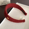 Detalle diadema burdeos de lana con textura suave y emblema metálico dorado de Corea - Burdeos