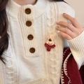 Dettaglio del ricamo a coniglio su un maglione beige in maglia a trecce con bottoni - Spilla Coniglio con Sciarpa