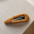 Close-up of mustard yellow knitted hair clip with black polka dots on soft fabric texture - Yellow Hollow Teardrop