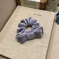 Macro detail of lavender velvet scrunchie and bow with soft luxury texture and sheen - Taro Purple