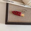 Close-up of a red popsicle-shaped hair clip with colorful rhinestones on a linen surface - Traceless Popsicle Shape