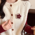 Détail de la broche étoile brodée sur gilet en maille beige et pull rouge - Style Étoile de Flocon de Neige
