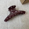 Detailed close-up of glossy brown butterfly hair claw clip with cream patterns - Brown Hanger Shape