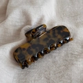 Detailed close-up of large tortoiseshell resin hair claw clip on white linen fabric - Dark Tortoiseshell