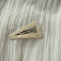 Detail of triangle acetate hair clip featuring cream marble texture and silver metal base - Off-white