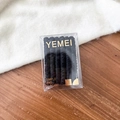 Detail of black spiral hair ties in a transparent elegant box on a soft wooden surface - Pure Black
