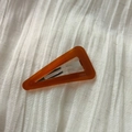 Detail of triangle acetate hair clip showing the France Handmade logo on amber resin - Brown