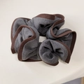 Detail van grijs en bruine scrunchie met focus op de stoftextuur en de geplooide randen - Grijs