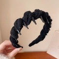 Close-up of black knitted headband with unique toothed spikes and textured fabric finish - Black