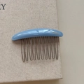 Close-up of light blue resin hair comb with metal teeth and handmade branding - Blue