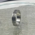 Primer plano de anillo giratorio de acero de titanio con textura de neumático para estrés - US 6 / Patrón de neumático / Plateado