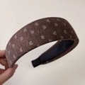 Detailed close-up of brown knit floral headband with thick fabric and snowflake pattern - Wide Coffee