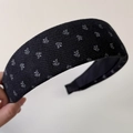 Close-up of vintage black knitted headband with delicate white floral embroidery patterns - Wide Black