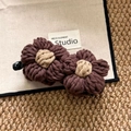 Close-up of handmade knitted flower hair clip with detailed wool texture and warm aesthetic - Brown