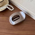 Close-up of vintage marble texture hair claw clip with golden Barrette France logo - Oval Milk Coffee