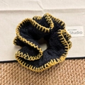 Detail of crochet hair scrunchie with black and yellow knit texture and refined craftsmanship - Black