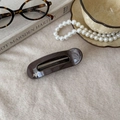 French retro acetate hair clip in dark tortoiseshell finish on beige knit background - Bar Oval Dark Brown