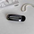 Detail of grey marble duckbill hair clip with golden script on a jewelry box - Bar Oval Dark Gray