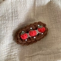 Détail d'une pince à cheveux au crochet faite main avec fraises rouges et perles blanches - Trois Fraises
