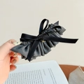 Detail of grey pleated fabric hair claw clip with black silk ribbons and gold heart charm - Gray