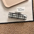 Primer plano de una pinza para el pelo rectangular grande con patrón de cuadros blancos y negros - Negro