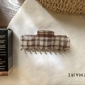 Dettaglio della molletta per capelli a scacchi marroni e bianchi in acetato chic - Marrone