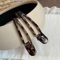 Detailed view of tortoiseshell pattern duckbill hair clips on a vintage fabric background - Grey Tortoise
