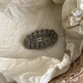 Detail of hand-knitted gray wavy edge hair clip with a minimalist forest style aesthetic - Grey Green