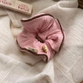 Detalle de coletero rosa con borde marrón y etiqueta artesanal sobre fondo textil - Coletero de tela / Rosa