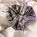 Detail of knitted striped scrunchie with purple fuzzy trim on beige fabric background - Gray with Purple Edge