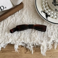 Detail of a dark tortoise shell banana hair clip on elegant white textured background - Bowknot Curve / Coffee Tortoise Shell