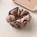 Makro-Detail von beige gestricktem Haargummi mit brauner Wellennaht und weicher Textur - Khaki