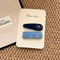Detalle de pinzas para el cabello de terciopelo y denim bordado con hilo de oro en tarjeta - Serie Azul