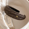 Gros plan détaillé d'un serre-tête en tricot marron café avec des rayures dorées - Marron