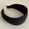 Close-up of wide black knitted headband featuring fine horizontal weaving textures - Black