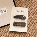 Detalle de set de pinzas para el cabello en terciopelo y encaje sobre tarjeta blanca - Gris